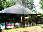 Bronze Pool Enclosure inside ornamental fencing. Steep Gable Hip Style Roof 